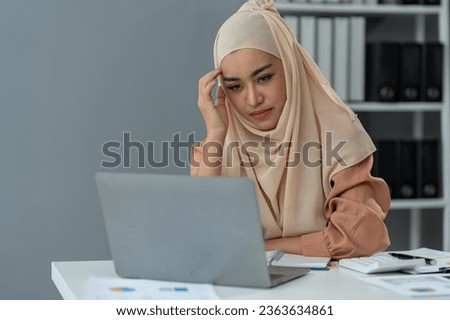 Muslim businesswoman who is tired, sleepy, bored from sitting at a desk for a long time and have office syndrome.