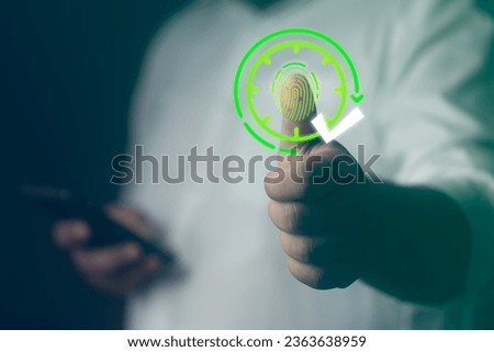 Fingerprint scan icon on visualizer screen while finger scanning for security access to check in with on time used to monitor when employees start work. HR technology in office Royalty-Free Stock Photo #2363638959