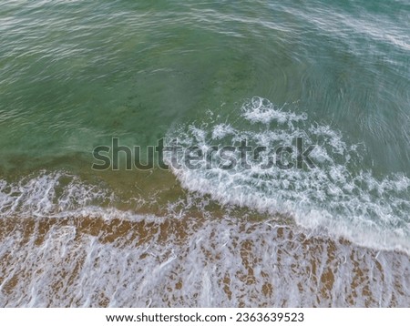 Summer sea nature background,Aerial view of Waves crashing on sandy shore,Sea surface ocean waves background,Top view beach background