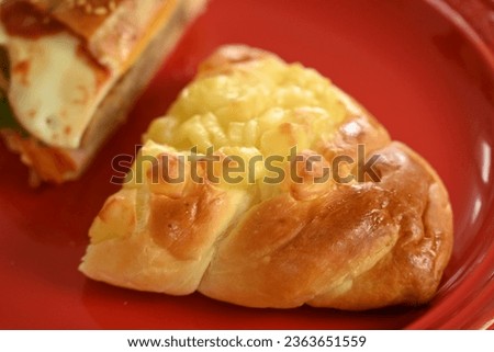 Hamburger and cheese bread cut on red plate