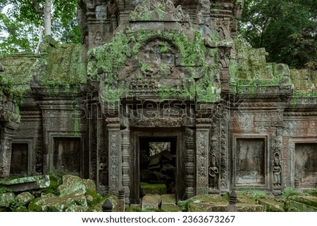 Green moss-covered stone building and bricks at Ta Prohm Tomb Raider temple gate entrance. Angkor Wat historical site Siem Reap, Cambodia Royalty-Free Stock Photo #2363673267