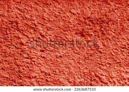 The texture of a relief, rough red wall.