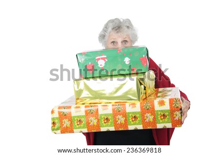 Old woman hiding behind christmas presents against a white background