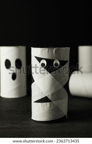 Mummy and ghost paper mockup on table on black background