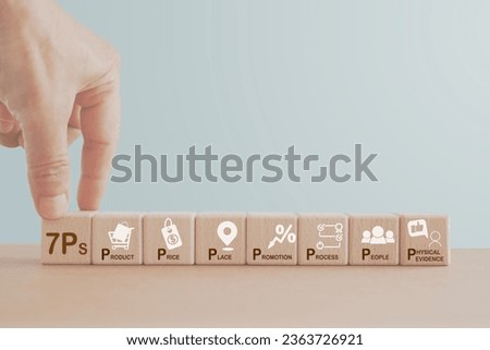 concept of 7ps of marketing mix. Hand hold wooden cube block with 7ps text and business icon on the others including copy space Royalty-Free Stock Photo #2363726921
