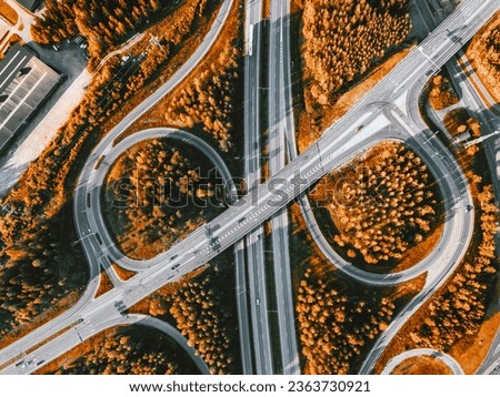 Aerial view of highway and overpass with autumn color woods on a fall day in rural Finland.