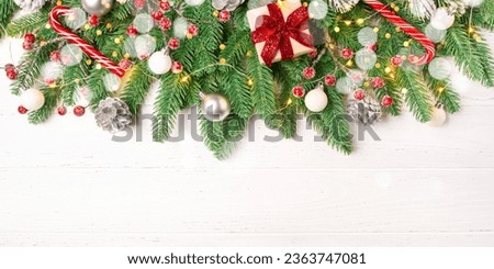 Christmas composition of spruce, cones and decorations on a white wooden table.