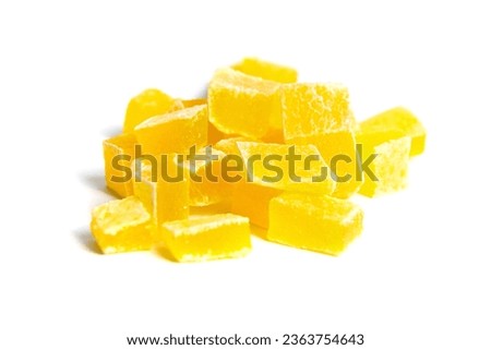 Dehydrated mango dices isolated on a white background. The vibrant orange-yellow hue of dehydrated mango cubes is visually appealing. Heap of candied diced fruits closeup