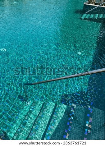 Metal rail and steps in outdoor swimming pool Royalty-Free Stock Photo #2363761721