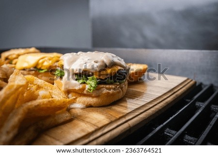 "Savor the moment with a juicy beef burger and crispy fries. Irresistible taste and perfect meal indulgence." Royalty-Free Stock Photo #2363764521