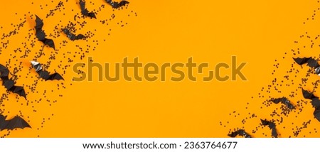 Halloween decorations concept. Black bats cut from paper on yellow background. Halloween decor and decorations for holiday