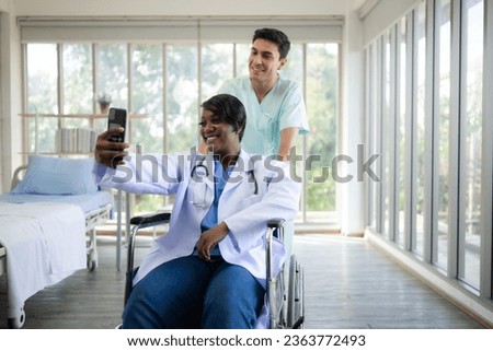 Portrait of nurse taking selfie with patient in wheelchair at hospital