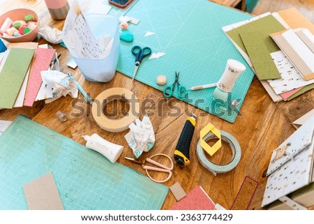 Scrapbook workshop. Cutting table with all types of scissors and adhesives Royalty-Free Stock Photo #2363774429