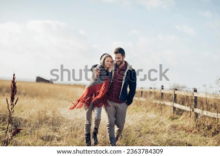 Young couple walking on a field on a farm in the countryside Royalty-Free Stock Photo #2363784309