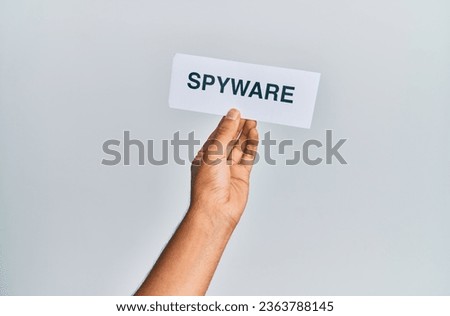 Hand of caucasian man holding paper with spyware word over isolated white background