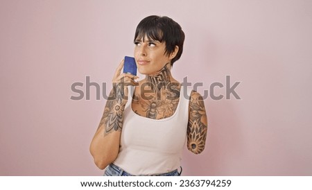 Hispanic woman with amputee arm holding credit card thinking over isolated pink background