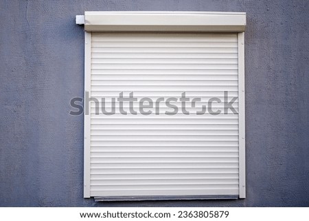 Rolling shutters, window with closed roller shutters. House facade with window on first floor, security and protection concept Royalty-Free Stock Photo #2363805879
