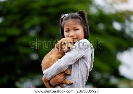 Young girl plays with a little puppy happily Inter-species love Love of people and pets