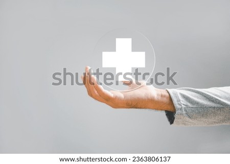Hand of a businessman holds a plus sign, symbolizing positivity, benefits, personal development, social network. Emphasizes value addition and incentives in a corporate context.