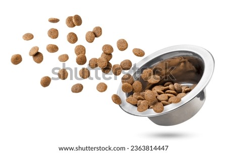 Dry cat food flies out of a bowl close-up on a white background. Isolated Royalty-Free Stock Photo #2363814447