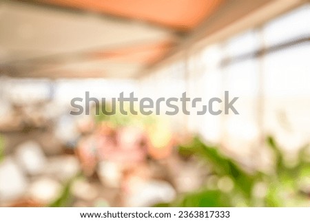 BLURRED OFFICE BACKGROUND, MODERN INTERIOR WITH BLURRY GREEN FLOWERS AND PEOPLE INSIDE Royalty-Free Stock Photo #2363817333