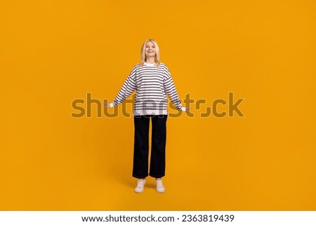 Full size photo of charming mature lady standing in new outfit isolated over bright color background
