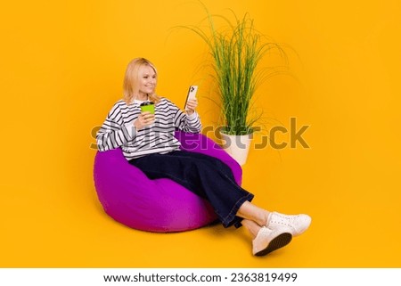 Photo of pensioner lady sitting bean chair drink cacao writing post in social network isolated bright color background