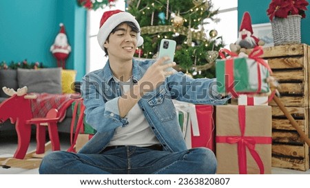 Young hispanic man celebrating christmas make photo to gift at home