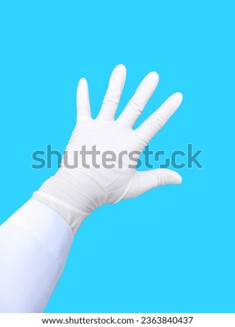 Doctor's hand about to perform surgery, doctor's hand showing index finger, The background of the picture is sea green.