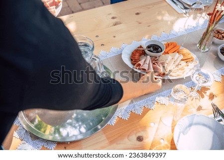 A tasty charcuterie board full of various cheese, ham and sausages