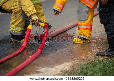 Firefighters are preparing a high-pressure hose to use to put out a fire.