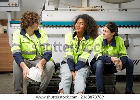 Portrait of a team of male and female employees Wear uniforms and take breaks to rest and talk. In the furniture industry, The background is a plywood machine, wooden boards, and a warehouse manager.