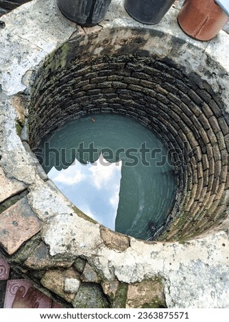 Photo of an old well whose water is greenish in color