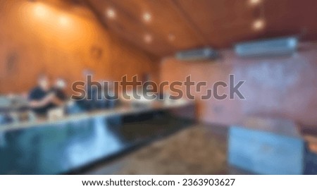 spacious bright interior in industrial cafe with rust walls, concrete floor, stainless steel counter and staff, blured view used as background for design. indoor modern cafe, defocused view.