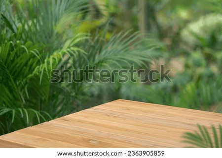Wood tabletop floor in outdoors blur green leaf tropical forest nature background.cosmetic natural product mock up placement pedestal stand display,jungle summer concept.