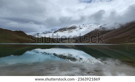 Chandra Tal Lake's Twilight Serenity: A unique and rare sight unfolds as the clouds blankets the mountain peaks and creates an otherworldly connection between the lake and the heavens.