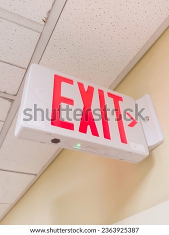 exit sign against a dark background symbolizing safety and escape, with green letters and arrow, conveying urgency and direction in an emergency