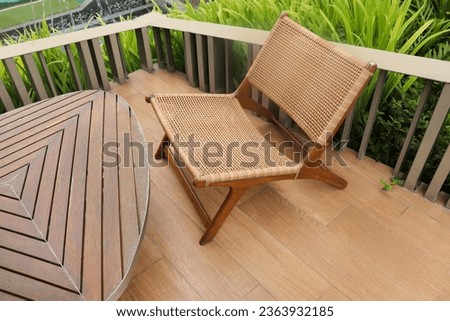 Rattan chair with backrest paired with a small wooden table set in the garden For sitting and relaxing