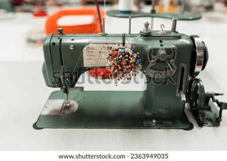 Sewing machine and pin cushion in textile workshop Royalty-Free Stock Photo #2363949035