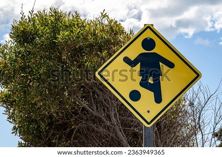 Yellow and black sign warning of children playing