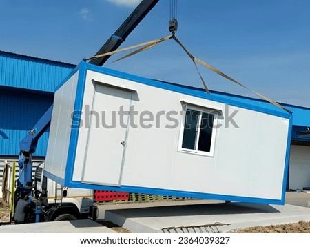 The Crane trucks transport the mobile office buildings or container site office for installation in the construction site area, project mobilization. Royalty-Free Stock Photo #2364039327