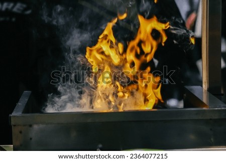 Orange flame from the fire on the pan. Royalty-Free Stock Photo #2364077215