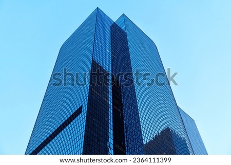 A skyscraper in the downtown LA stands tall against the backdrop of a perfectly clear blue sky.