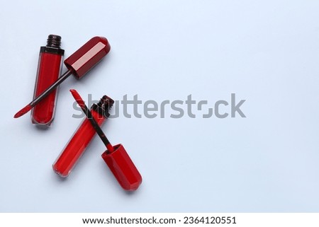 Different stylish red lipsticks on blue background