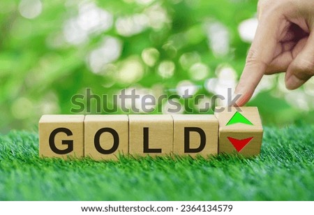Hand turned wooden cubes with word GOLD to arrow up and down. Interest rate, stocks, financial, cut loss, economic, business and gold price are going down or up concept.Copy space.