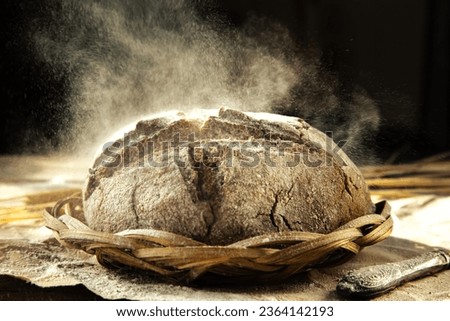 Freshly baked traditional bread in a sprinkle of flour. Yeast-free rye bread on the kitchen table, close-up. Food background. Rustic style. Royalty-Free Stock Photo #2364142193