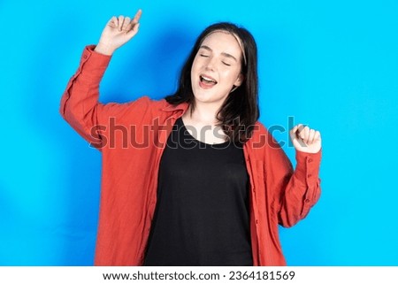 Photo of upbeat Young beautiful woman has fun and dances carefree wear being in perfect mood makes movements. Spends free time on disco party