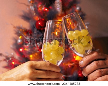 New Year's Tradition: Twelve Grapes on the Glasses and a Festive Tree. Royalty-Free Stock Photo #2364185273