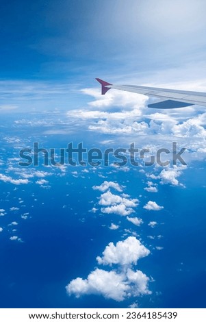 Aerial shot above the clouds. view of the sky and blue ocean from airplane.
