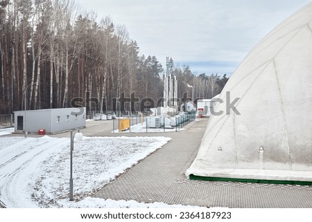 Inflatable air dome stadium. Inflated Football soccer air dome. Modern architecture example pneumatic stadium dome with heat generators, hot air blower and air conditioning system near winter forest. Royalty-Free Stock Photo #2364187923